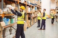 Warehouse worker taking package in the shelf in a large warehouse in a